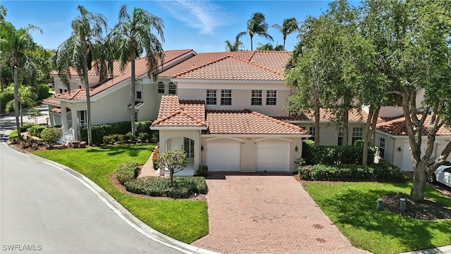 700 L Ambiance Cir Unit 202, Naples, FL 34108 - mediterranean / spanish-style home with decorative driveway, a tiled roof, a front lawn, and stucco siding