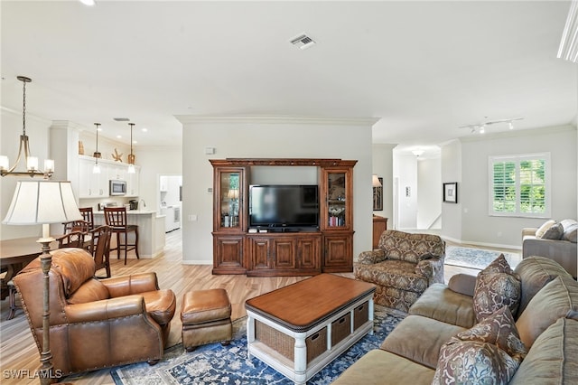 700 L Ambiance Cir Unit 202, Naples, FL 34108 - living area with ornamental molding, light wood finished floors, and a chandelier