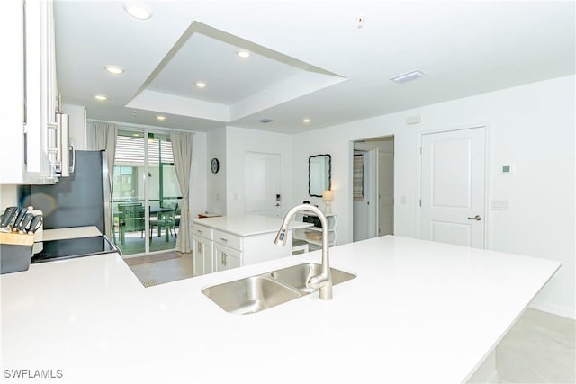 5467 Double Eagle Cir Unit 3212, Ave Maria, FL 34142 - kitchen with white cabinetry, a tray ceiling, light countertops, a center island, and recessed lighting