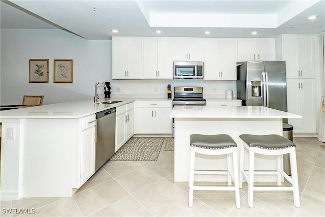 5467 Double Eagle Cir Unit 3212, Ave Maria, FL 34142 - kitchen featuring appliances with stainless steel finishes, recessed lighting, a raised ceiling, a peninsula, and white cabinets