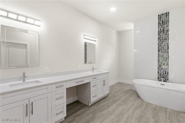 1159 SW 5th Ter, Cape Coral, FL 33991 - bathroom featuring double vanity, a freestanding tub, wood finished floors, and recessed lighting