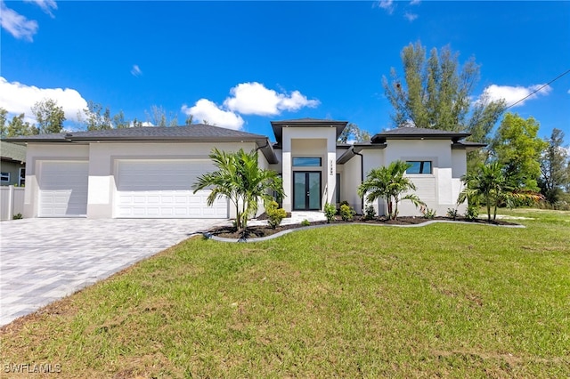 1159 SW 5th Ter, Cape Coral, FL 33991 - view of front of property with stucco siding, an attached garage, decorative driveway, a front lawn, and french doors