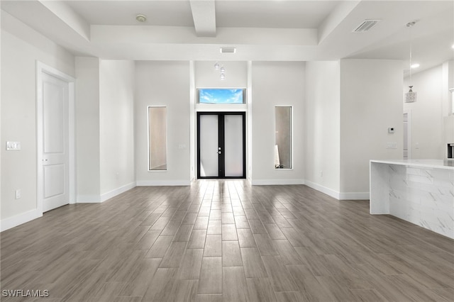1159 SW 5th Ter, Cape Coral, FL 33991 - unfurnished living room featuring wood finished floors and beam ceiling