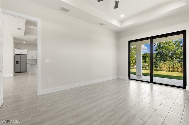1159 SW 5th Ter, Cape Coral, FL 33991 - empty room with a tray ceiling, a ceiling fan, recessed lighting, and light wood-style floors