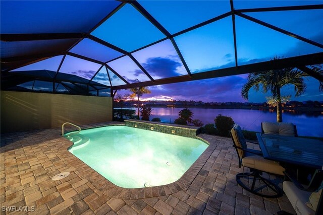 7773 Jacaranda Ln, Naples, FL 34114 - pool at dusk with an outdoor pool, a patio area, a water view, and a lanai