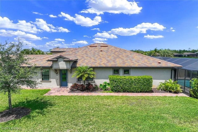 7773 Jacaranda Ln, Naples, FL 34114 - view of front of home with stucco siding, a front yard, and glass enclosure