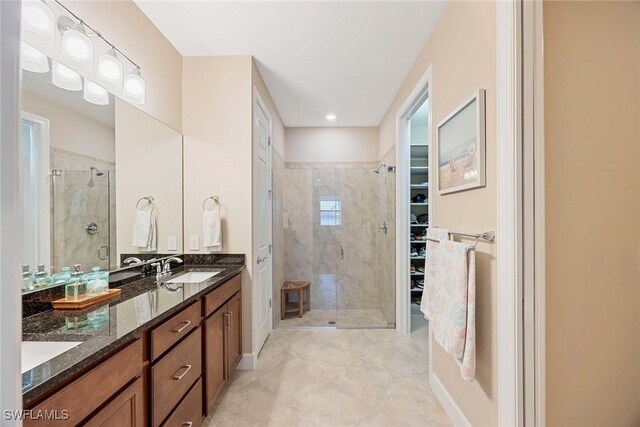 7773 Jacaranda Ln, Naples, FL 34114 - bathroom featuring a shower stall, a spacious closet, and double vanity