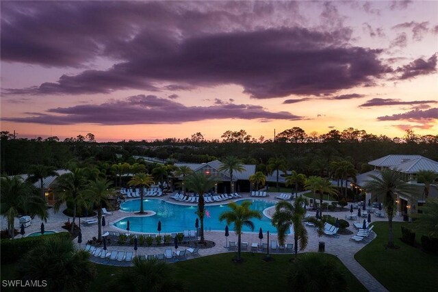 7773 Jacaranda Ln, Naples, FL 34114 - pool at dusk with a community pool and a patio