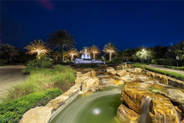 7773 Jacaranda Ln, Naples, FL 34114 - pool at twilight featuring a garden pond
