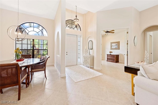3820 Ruby Way, Naples, FL 34114 - foyer with a chandelier, arched walkways, a high ceiling, and light tile patterned flooring