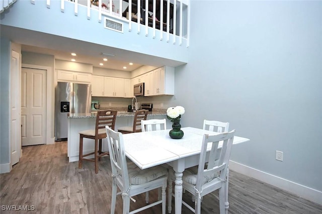 8849 Somerset Blvd, Fort Myers, FL 33919 - dining area with light wood finished floors, recessed lighting, and a towering ceiling