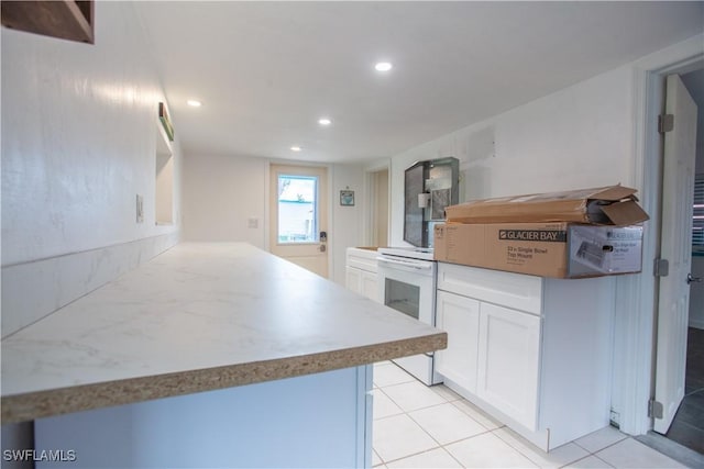 2595 Pine St, Matlacha, FL 33993 - kitchen featuring white cabinets, recessed lighting, light tile patterned floors, and a peninsula