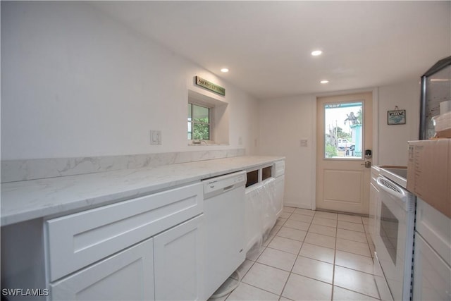 2595 Pine St, Matlacha, FL 33993 - kitchen with white appliances, recessed lighting, light tile patterned floors, light stone countertops, and white cabinetry