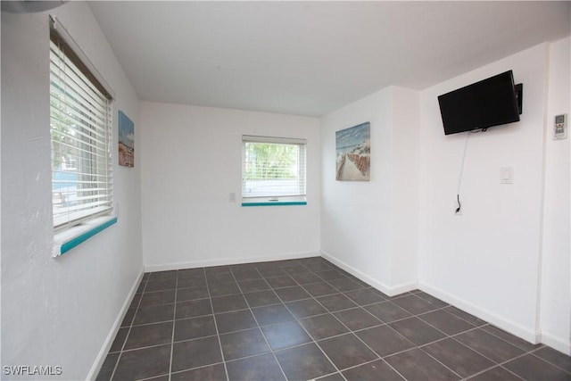 2595 Pine St, Matlacha, FL 33993 - empty room with dark tile patterned floors and baseboards
