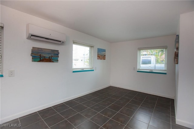 2595 Pine St, Matlacha, FL 33993 - unfurnished room with a wall unit AC, healthy amount of natural light, and dark tile patterned flooring