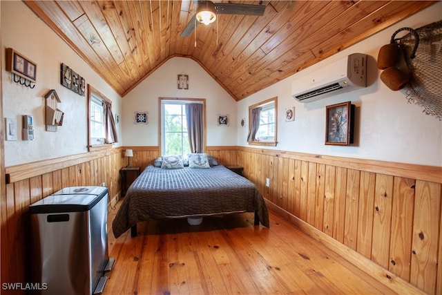 2595 Pine St, Matlacha, FL 33993 - bedroom with a wainscoted wall, a wall mounted air conditioner, wood ceiling, wood walls, and hardwood / wood-style floors