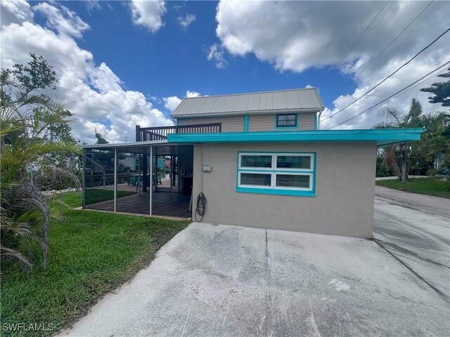 2595 Pine St, Matlacha, FL 33993 - rear view of house with stucco siding, a yard, a patio, and a metal roof