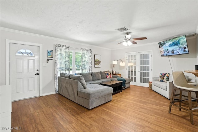 1423 Charles Rd, Fort Myers, FL 33919 - living room with french doors, light wood-type flooring, a ceiling fan, ornamental molding, and a textured ceiling