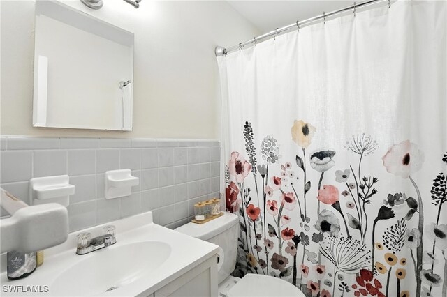1423 Charles Rd, Fort Myers, FL 33919 - full bath featuring tile walls, curtained shower, vanity, and a wainscoted wall