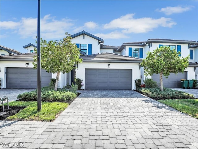 7524 Carnegie Way, Naples, FL 34119 - view of front of property featuring decorative driveway, a garage, stucco siding, and a tiled roof
