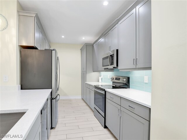 7524 Carnegie Way, Naples, FL 34119 - kitchen with appliances with stainless steel finishes, gray cabinets, recessed lighting, and tasteful backsplash