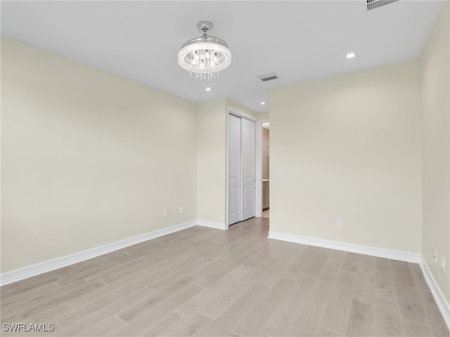 7524 Carnegie Way, Naples, FL 34119 - empty room featuring light wood finished floors, a chandelier, and recessed lighting