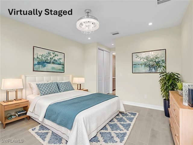 7524 Carnegie Way, Naples, FL 34119 - bedroom with a chandelier, light wood-type flooring, recessed lighting, and a closet