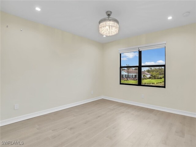 7524 Carnegie Way, Naples, FL 34119 - empty room with light wood-style floors, a chandelier, recessed lighting, and a smoke detector