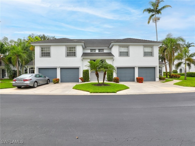 1170 Partridge Ln Unit 202, Naples, FL 34104 - view of front facade with a garage, concrete driveway, and stucco siding