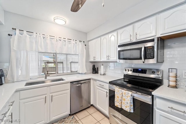 17236 Lee Rd, Fort Myers, FL 33967 - kitchen with appliances with stainless steel finishes, white cabinetry, decorative backsplash, and light tile patterned flooring