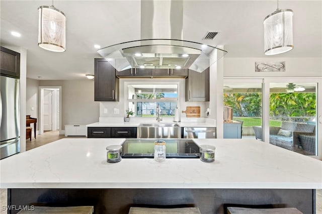 718 Coral Dr, Cape Coral, FL 33904 - kitchen featuring island range hood, appliances with stainless steel finishes, a center island, and light stone countertops