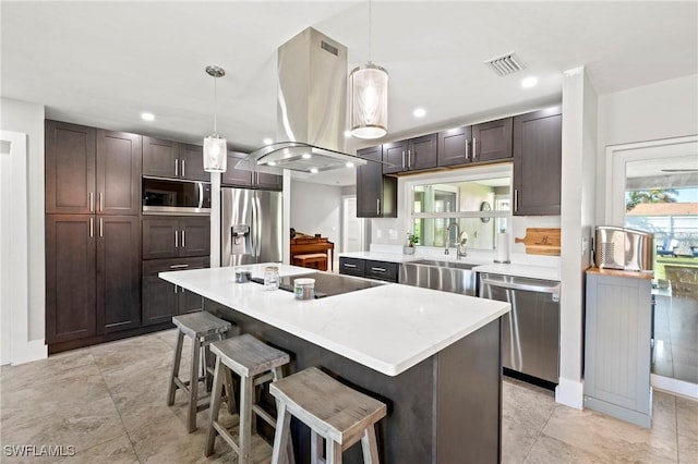 718 Coral Dr, Cape Coral, FL 33904 - kitchen with stainless steel appliances, island exhaust hood, dark brown cabinets, a kitchen breakfast bar, and light countertops