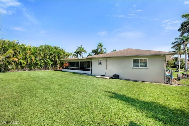 718 Coral Dr, Cape Coral, FL 33904 - rear view of house with stucco siding and a sunroom