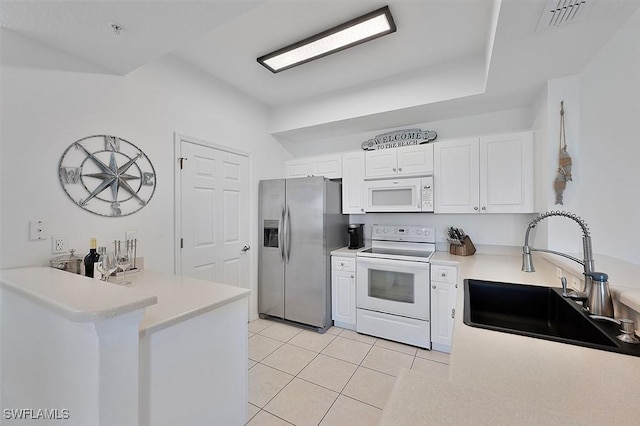 9035 Colby Dr Unit 2322, Fort Myers, FL 33919 - kitchen featuring white appliances, a peninsula, white cabinetry, light tile patterned floors, and light countertops