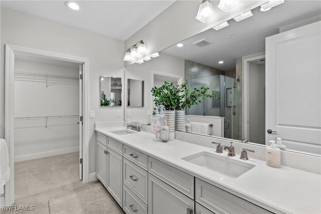 2609 Seychelles Cir Unit 1603, Naples, FL 34112 - bathroom with double vanity, a stall shower, a spacious closet, and recessed lighting