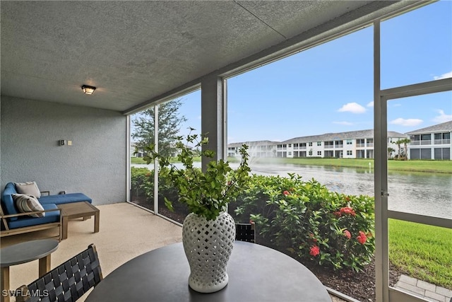 2609 Seychelles Cir Unit 1603, Naples, FL 34112 - sunroom / solarium featuring a water view, a textured wall, carpet floors, a textured ceiling, and floor to ceiling windows