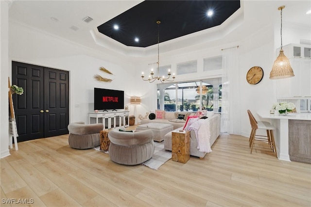 8920 Lely Island Cir, Naples, FL 34113 - living area featuring a chandelier, light wood finished floors, crown molding, and a tray ceiling