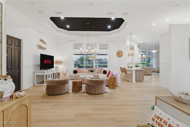 8920 Lely Island Cir, Naples, FL 34113 - living room featuring a raised ceiling, light wood-style flooring, a chandelier, and recessed lighting