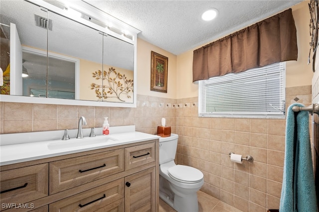 7400 College Pkwy Unit 59C, Fort Myers, FL 33907 - bathroom with tile walls, vanity, a textured ceiling, tile patterned floors, and wainscoting