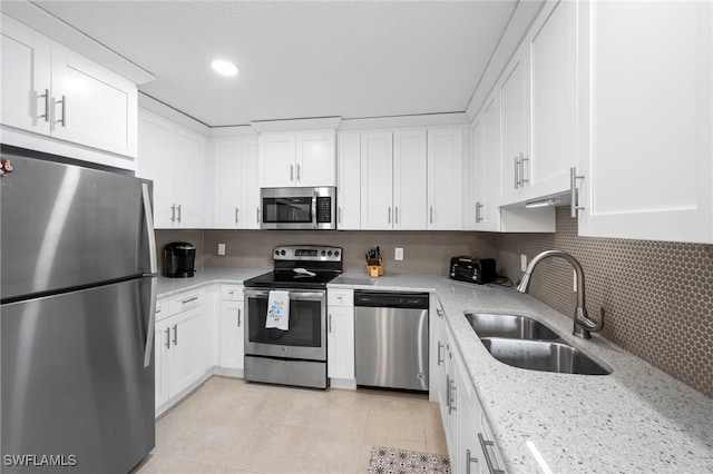 7400 College Pkwy Unit 59C, Fort Myers, FL 33907 - kitchen featuring appliances with stainless steel finishes, white cabinetry, decorative backsplash, light tile patterned flooring, and recessed lighting