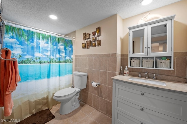 7400 College Pkwy Unit 59C, Fort Myers, FL 33907 - bathroom featuring tile walls, a textured ceiling, vanity, tile patterned flooring, and a wainscoted wall
