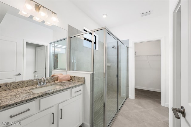 14044 Hunter Oak Dr, Fort Myers, FL 33913 - bathroom featuring vanity, a shower stall, a walk in closet, and tile patterned flooring