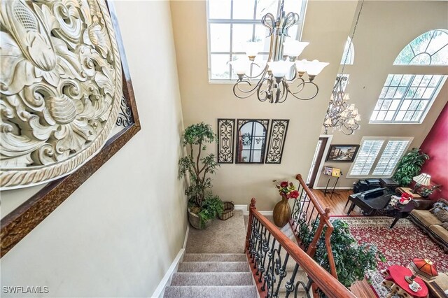 1841 Senegal Date Dr, Naples, FL 34119 - stairway with a chandelier, a high ceiling, healthy amount of natural light, and carpet flooring