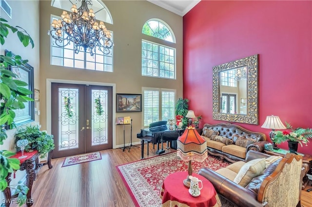 1841 Senegal Date Dr, Naples, FL 34119 - living room with french doors, a chandelier, crown molding, a towering ceiling, and wood finished floors