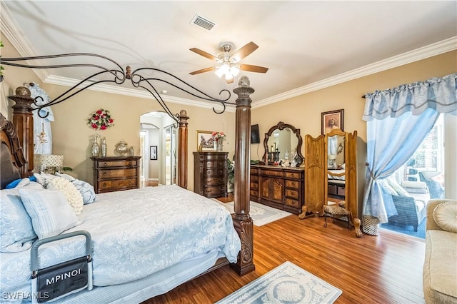1841 Senegal Date Dr, Naples, FL 34119 - bedroom with wood finished floors, crown molding, arched walkways, and a ceiling fan