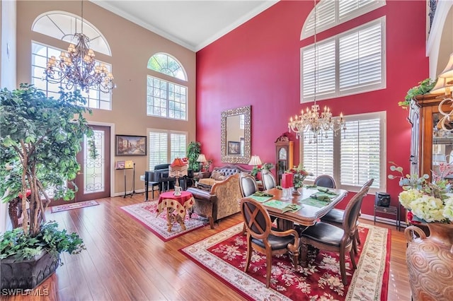 1841 Senegal Date Dr, Naples, FL 34119 - dining space featuring a chandelier, a high ceiling, ornamental molding, hardwood / wood-style flooring, and healthy amount of natural light