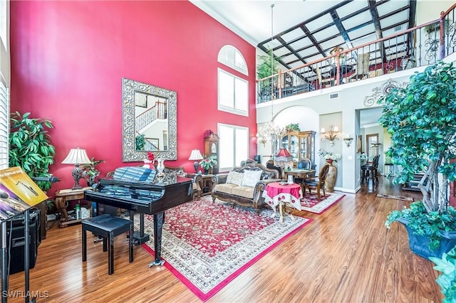 1841 Senegal Date Dr, Naples, FL 34119 - living room with a towering ceiling, wood finished floors, crown molding, and a chandelier