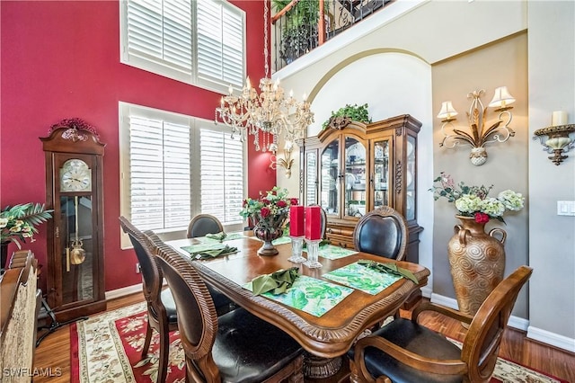 1841 Senegal Date Dr, Naples, FL 34119 - dining space with a chandelier, a towering ceiling, and wood finished floors