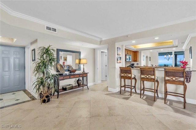4753 Estero Blvd Unit 1405, Fort Myers Beach, FL 33931 - kitchen with stainless steel microwave, crown molding, a raised ceiling, a kitchen breakfast bar, and a chandelier
