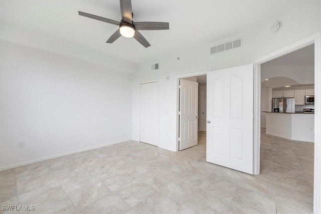 12980 Positano Cir Unit 306, Naples, FL 34105 - unfurnished bedroom with stainless steel fridge with ice dispenser, arched walkways, a closet, and ceiling fan